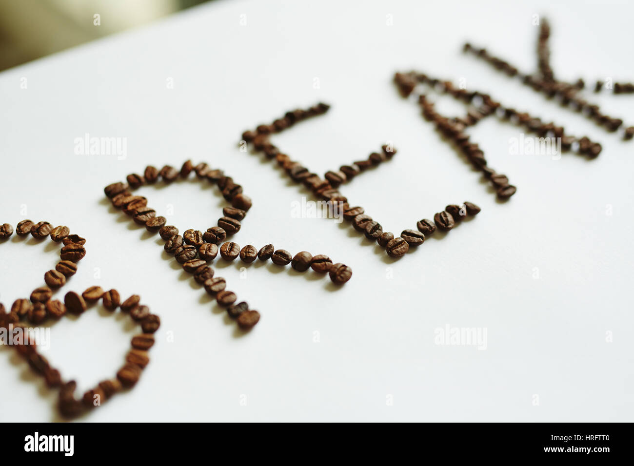 Creative coffee break concept: Word Break laid out on white table with