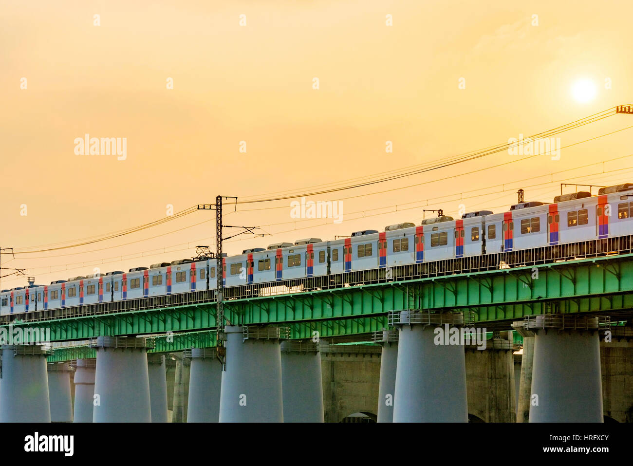 Train over a river on a railway track with sunset Stock Photo