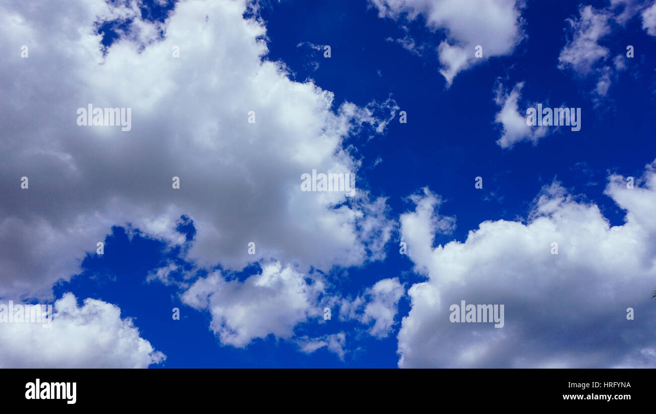 White fluffy clouds on a bright blue sky Stock Photo - Alamy