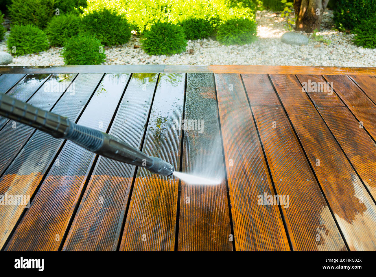cleaning terrace with a power washer - high water pressure cleaner on wooden terrace surface Stock Photo