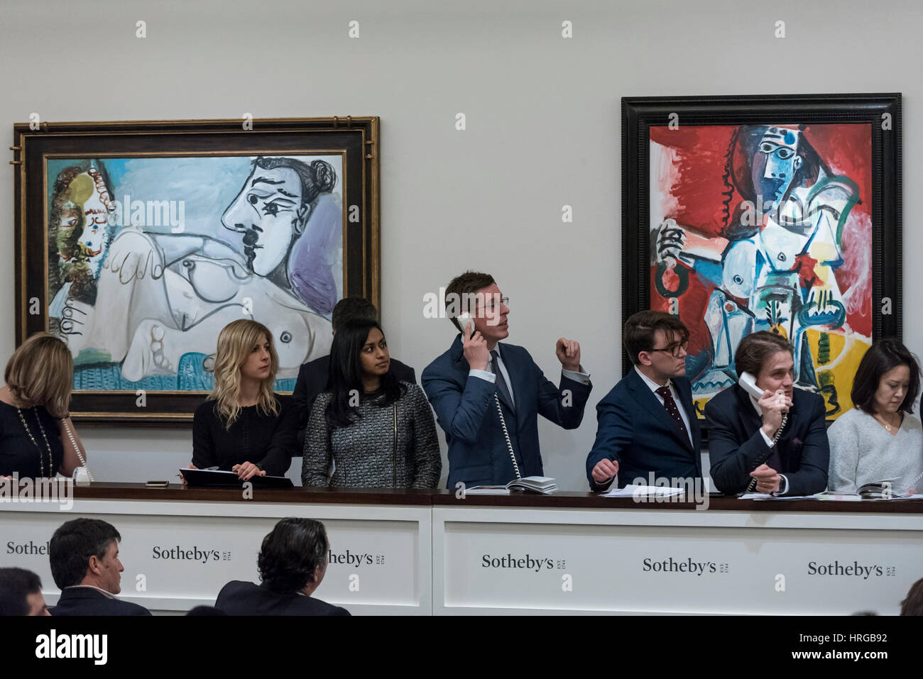 London, UK.  1 March 2017. Sotheby's staff, bidding on behalf of telephone clients, stand in front of (L to R) 'Femme Nue Assise' by Pablo Picasso which sold for a hammer price of GBP12m (est. GBP9.5-12.5m) and 'Femme Assise Dans Un Fauteuil Sur Fond Blanc' by Pablo Picasso which sold for a hammer price of GBP10.6m (est GBP6.5-9.5m), at the evening sale of Impressionist and Surrealist Art at Sotheby's in New Bond Street.  Credit: Stephen Chung / Alamy Live News Stock Photo