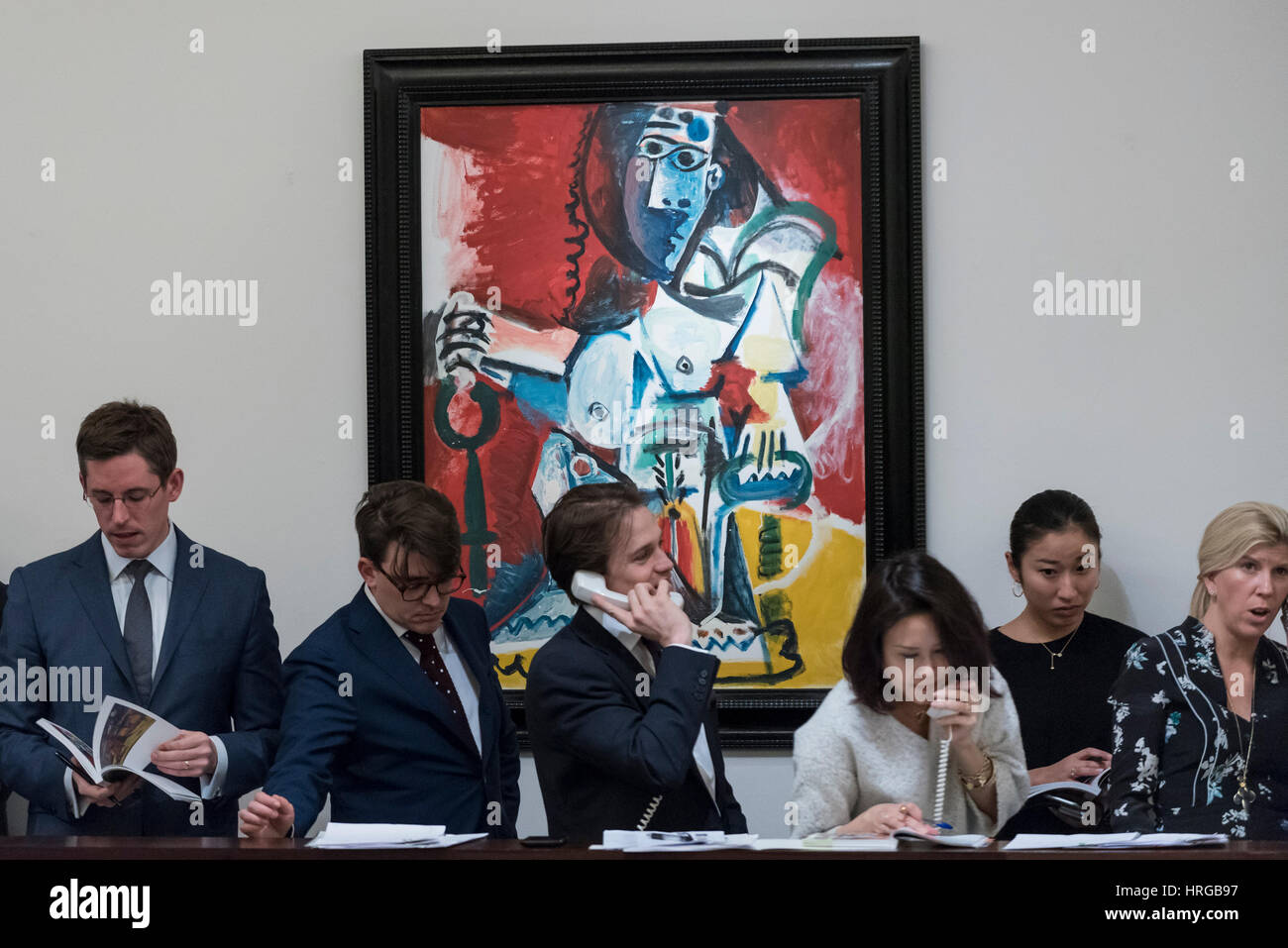 London, UK.  1 March 2017. Sotheby's staff, bidding on behalf of telephone clients, stand in front of 'Femme Nue Assise' by Pablo Picasso which sold for a hammer price of GBP12m (est. GBP9.5-12.5m) at the evening sale of Impressionist and Surrealist Art at Sotheby's in New Bond Street.  Credit: Stephen Chung / Alamy Live News Stock Photo