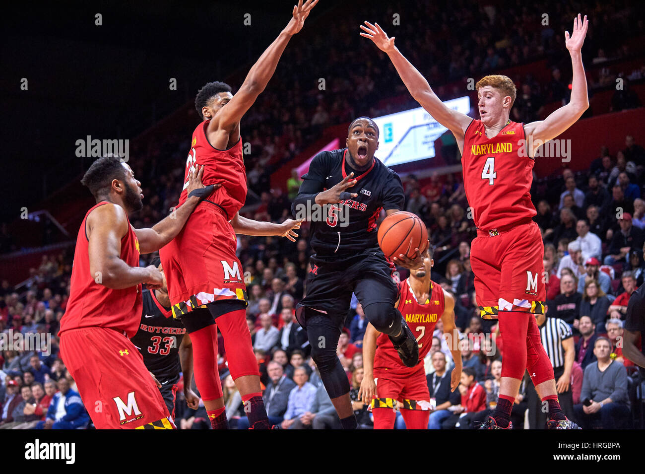Rutgers' guard Mike Williams (5) drives to the basket past Maryland's  forwards Justin Jackson (21) and Kevin Huerter (4) in the second half at  the Louis Brown Athletic Center in Piscataway, New