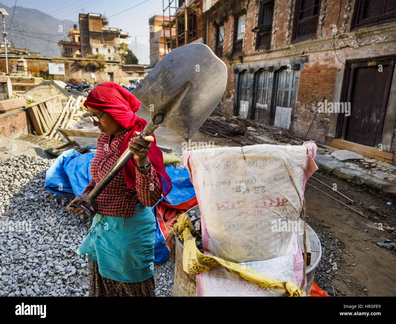 Sankhu, Central Development Region, Nepal. 2nd Mar, 2017. A laborer fills a basket with gravel for a home being rebuilt in Sankhu after the 2015 earthquake. The building on the right is a 300 year old home that is no longer usable and will be torn down. There is more construction and rebuilding going on in Sankhu, west of central Kathmandu, than in many other parts of the Kathmandu Valley nearly two years after the earthquake of 25 April 2015 that devastated Nepal. In some villages in the Kathmandu valley workers are working by hand to remove ruble and dig out destroyed buildings. About 9, 00 Stock Photo