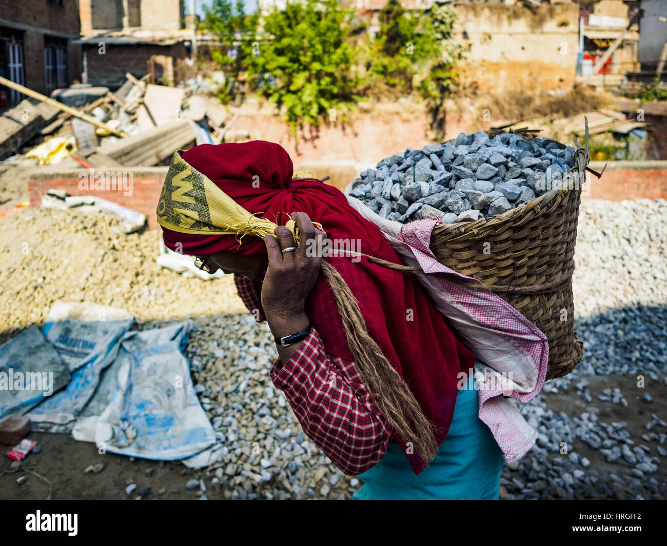 Sankhu, Central Development Region, Nepal. 2nd Mar, 2017. A laborer carries carry gravel to a home being rebuilt in Sankhu. Each basket weighs about 80 pounds. Almost all of the work is being done by hand. There is more construction and rebuilding going on in Sankhu, west of central Kathmandu, than in many other parts of the Kathmandu Valley nearly two years after the earthquake of 25 April 2015 that devastated Nepal. In some villages in the Kathmandu valley workers are working by hand to remove ruble and dig out destroyed buildings. About 9,000 people were killed and another 22,000 injured Stock Photo