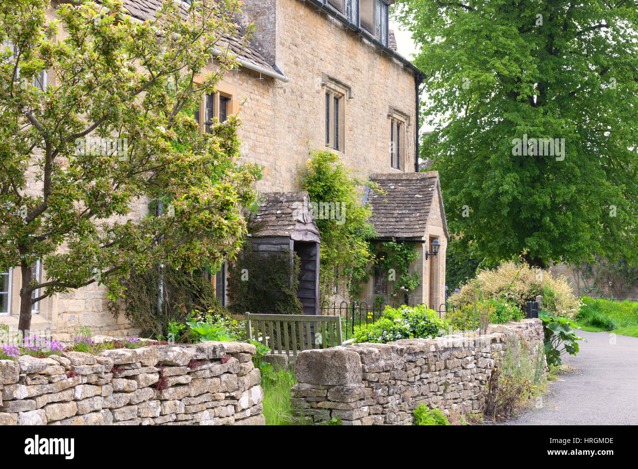 Traditional english cottages with front gardens enclosed by a dry stone wall, by a footpath, in a rural village . Stock Photo