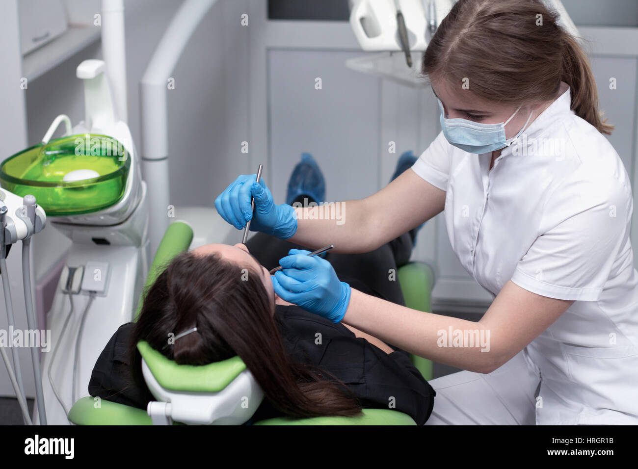 Dentist at work examining woman's teeth in dental clinic Stock Photo