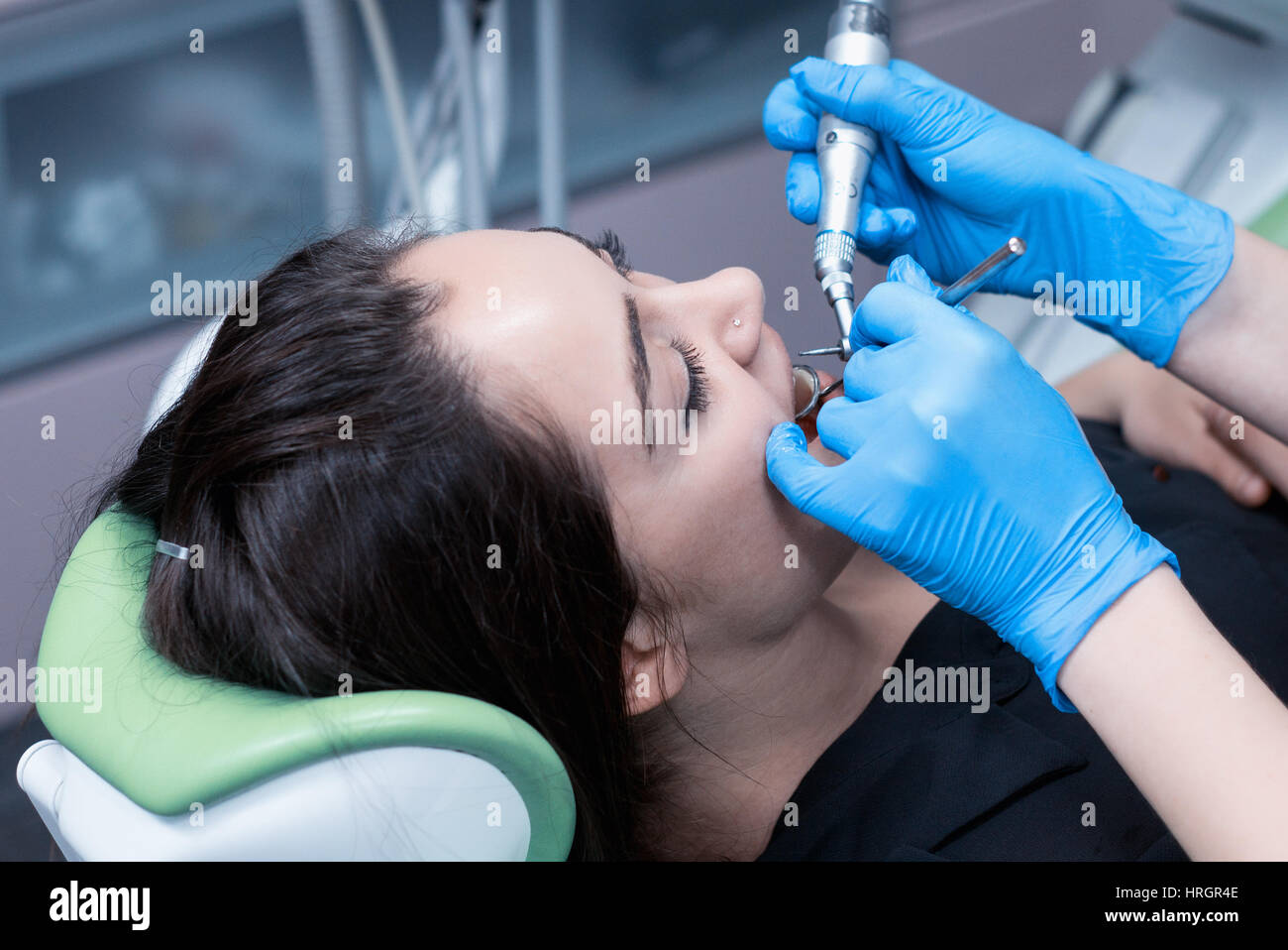 close up shot of female patient at the dentist drill the tooth with a turbine and making dental fillings Stock Photo