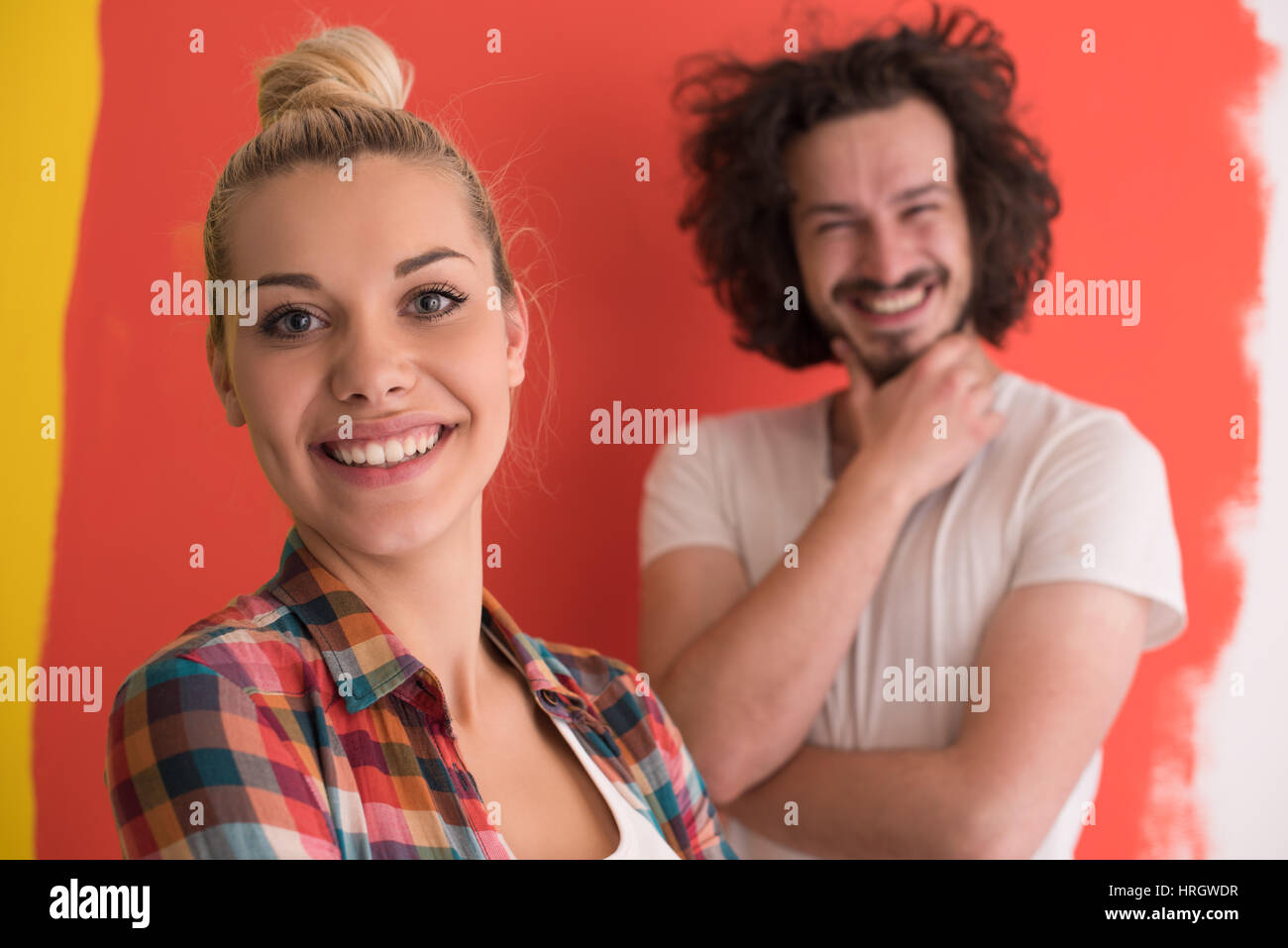Portrait of a happy young smiling couple in love over color background ...
