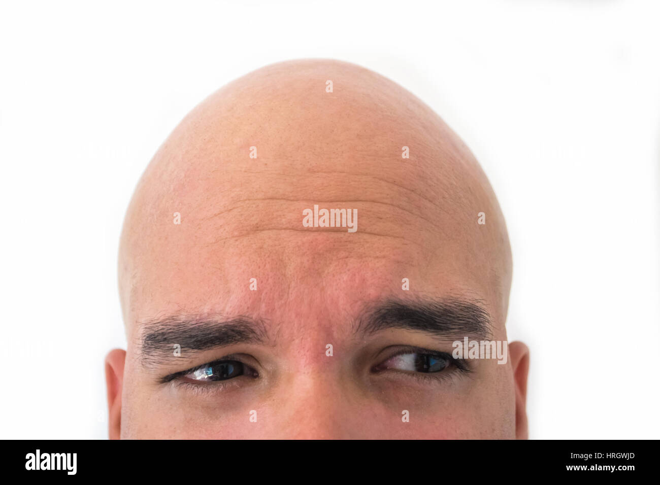 Half face of bald man in white background. Closeup of the eyes. Afraid mood Stock Photo