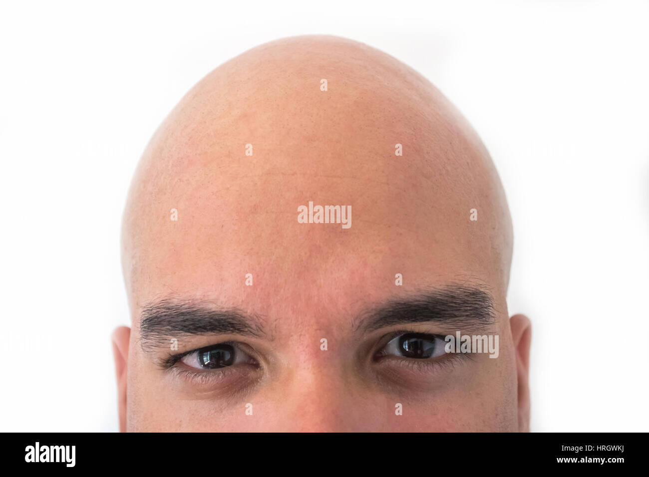 Half face of bald man in white background. Closeup of the eyes. Stock Photo