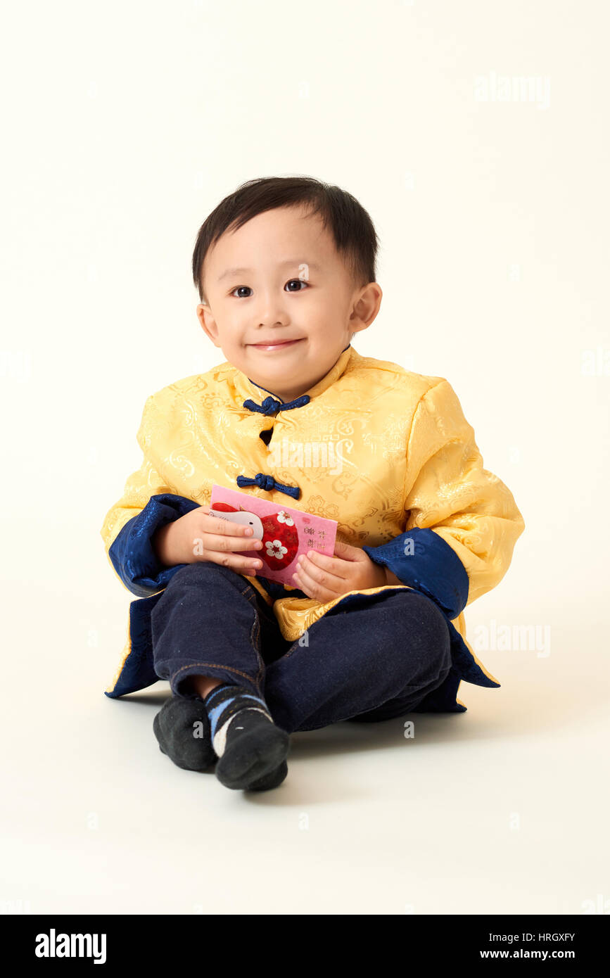 Chinese baby boy in traditional Chinese New Year outfit celebrating