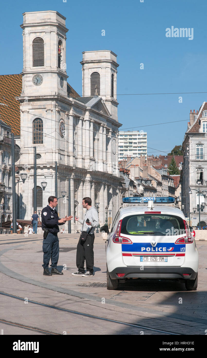 Young man having altercation with Policeman in Place Claude Francois Jouffroy near Pont Battant Besancon France with Church Eglise Sainte Madeleine de Stock Photo
