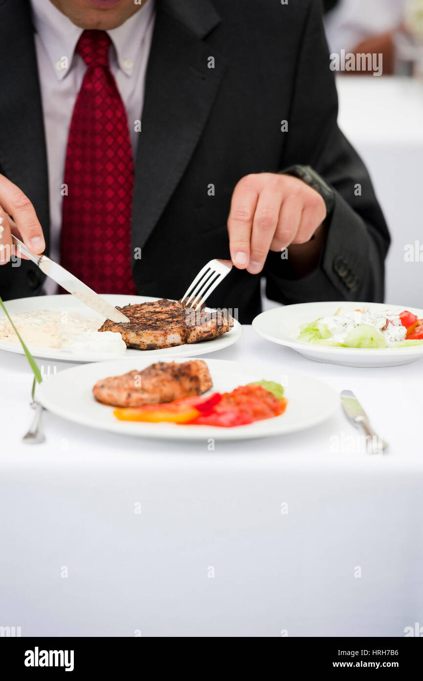 Businessmann isst Kotelett - business man eats cutlet Stock Photo
