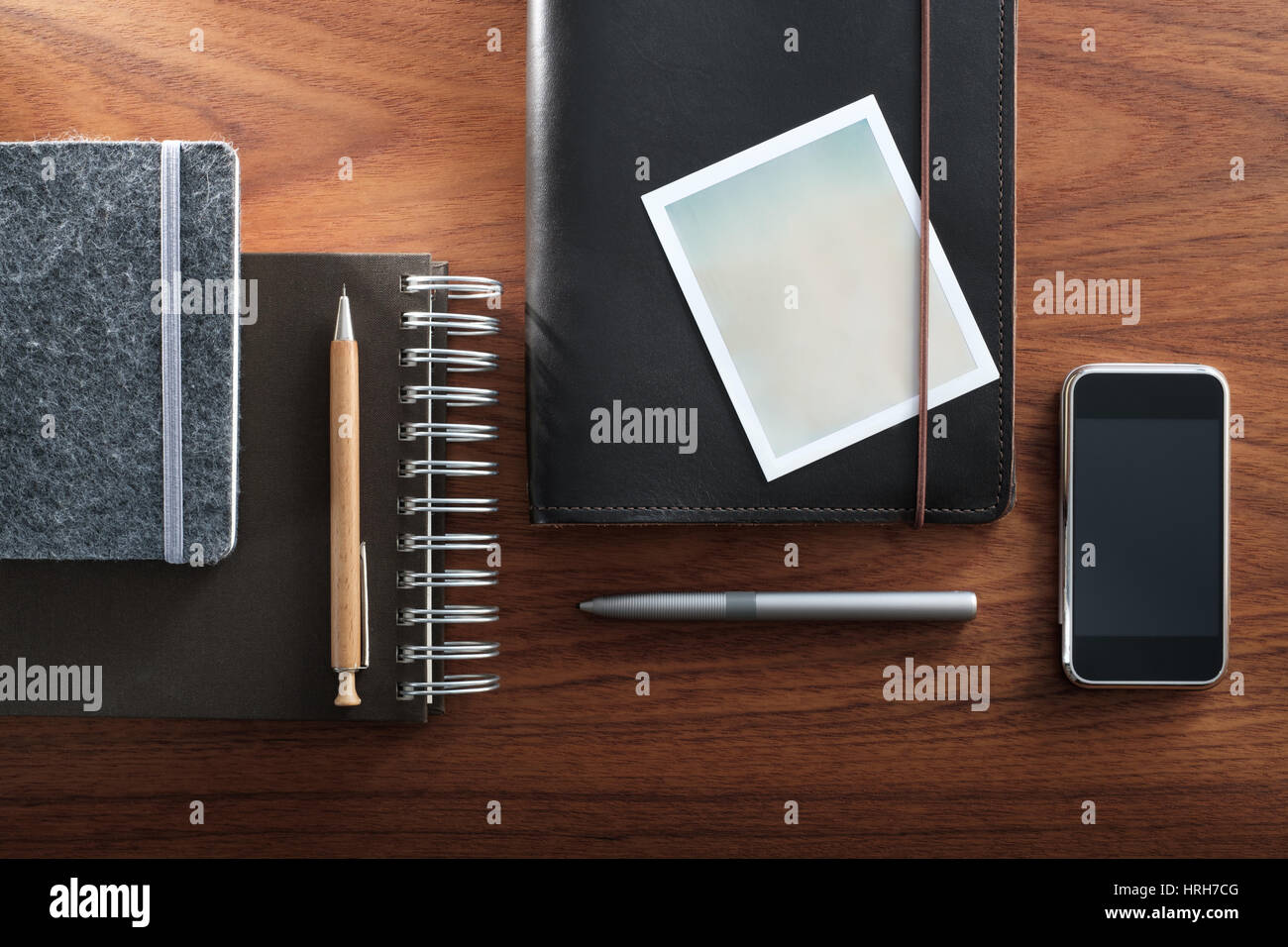 Notepads, instant camera film frame and pencil vs smartphone and digital pen. Analog and digital. Stock Photo