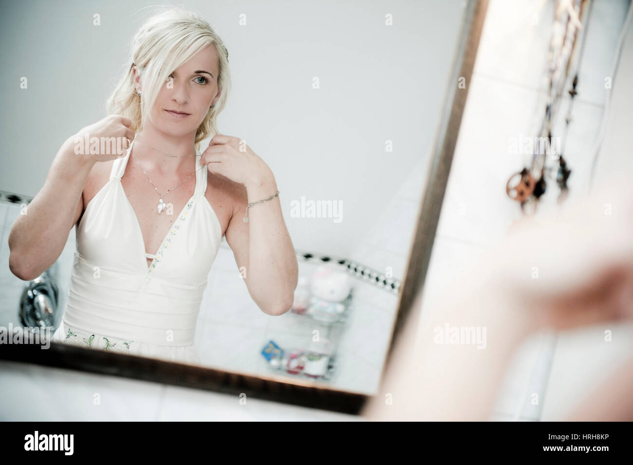 Model released, Braut vor dem Spiegel haengt sich Halskette um - bride front of the mirror Stock Photo