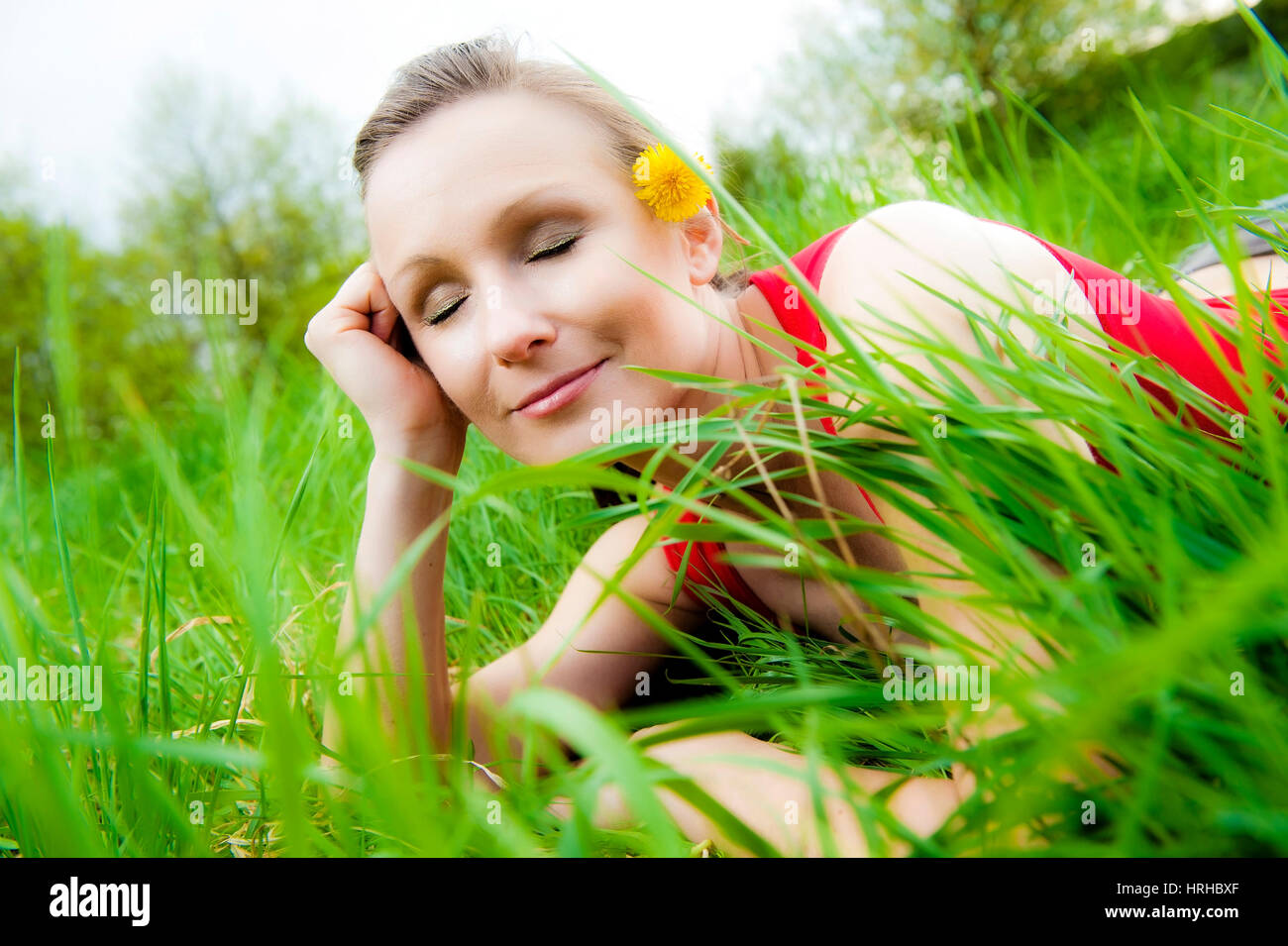 Model released, Junge Frau liegt entspannt in Fruehlingswiese - woman relaxing in a spring meadow Stock Photo