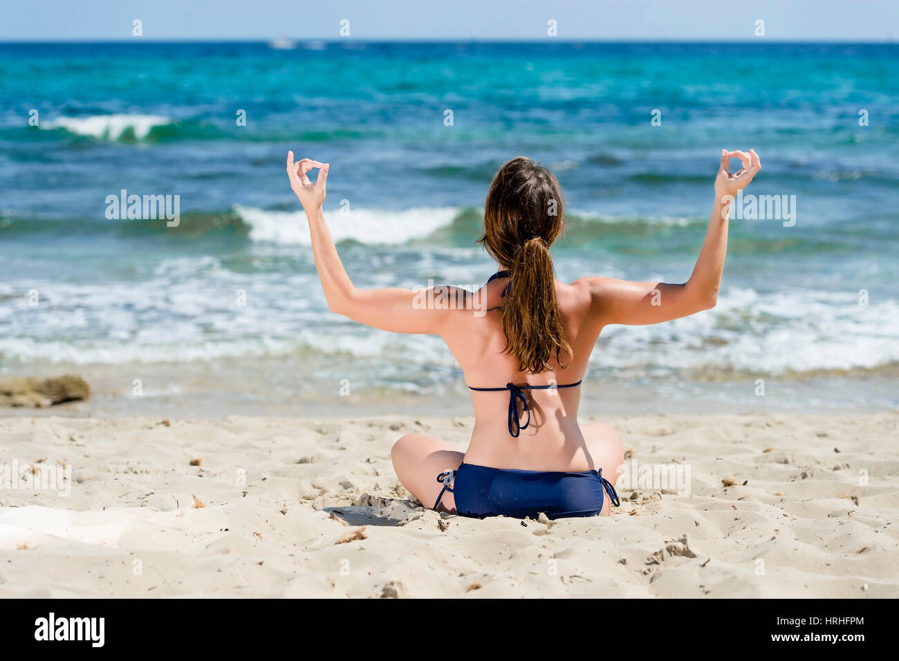 Frau im Bikini macht Joga am Strand, Spanien, Ibiza - woman does yoga at the beach, Ibiza, Spain Stock Photo