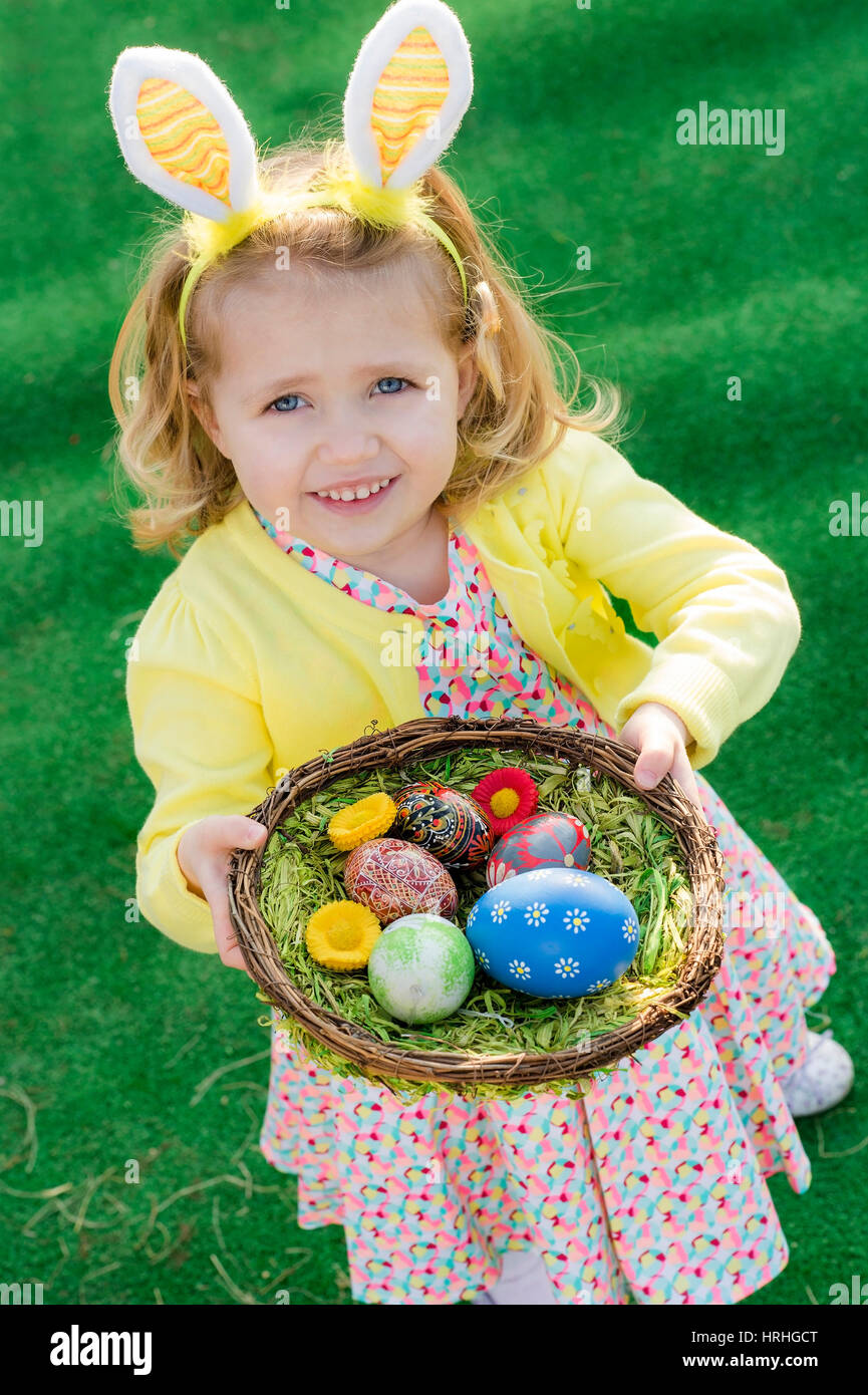 Maedchen mit Hasenohren haelt Osternest in der Hand - Easter girl with Easter nest Stock Photo