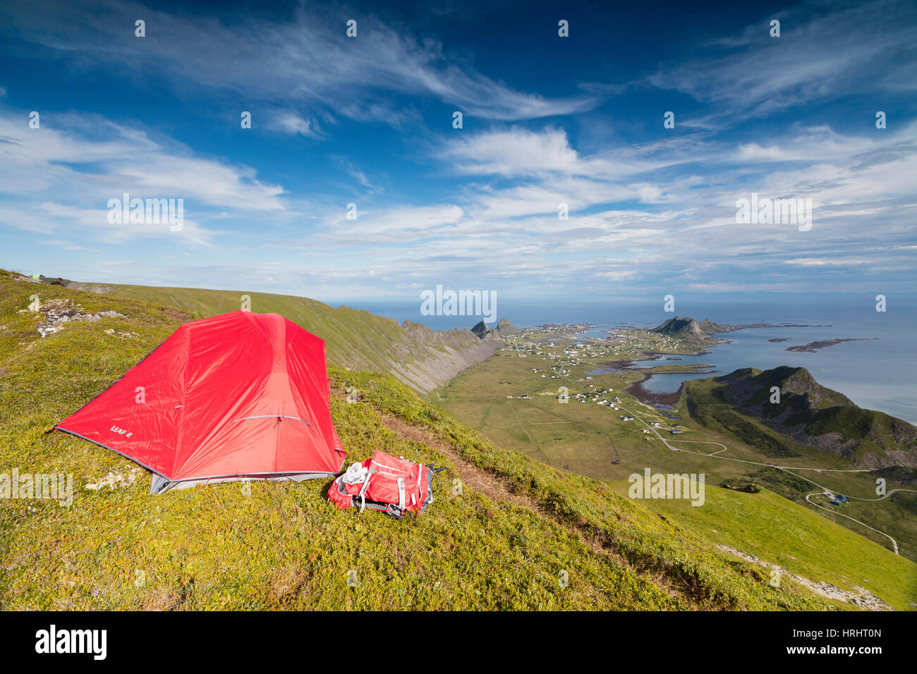 Tent on mountain ridge overlooking meadows and sea, Sorland, Vaeroy Island, Nordland county, Lofoten archipelago, Norway Stock Photo
