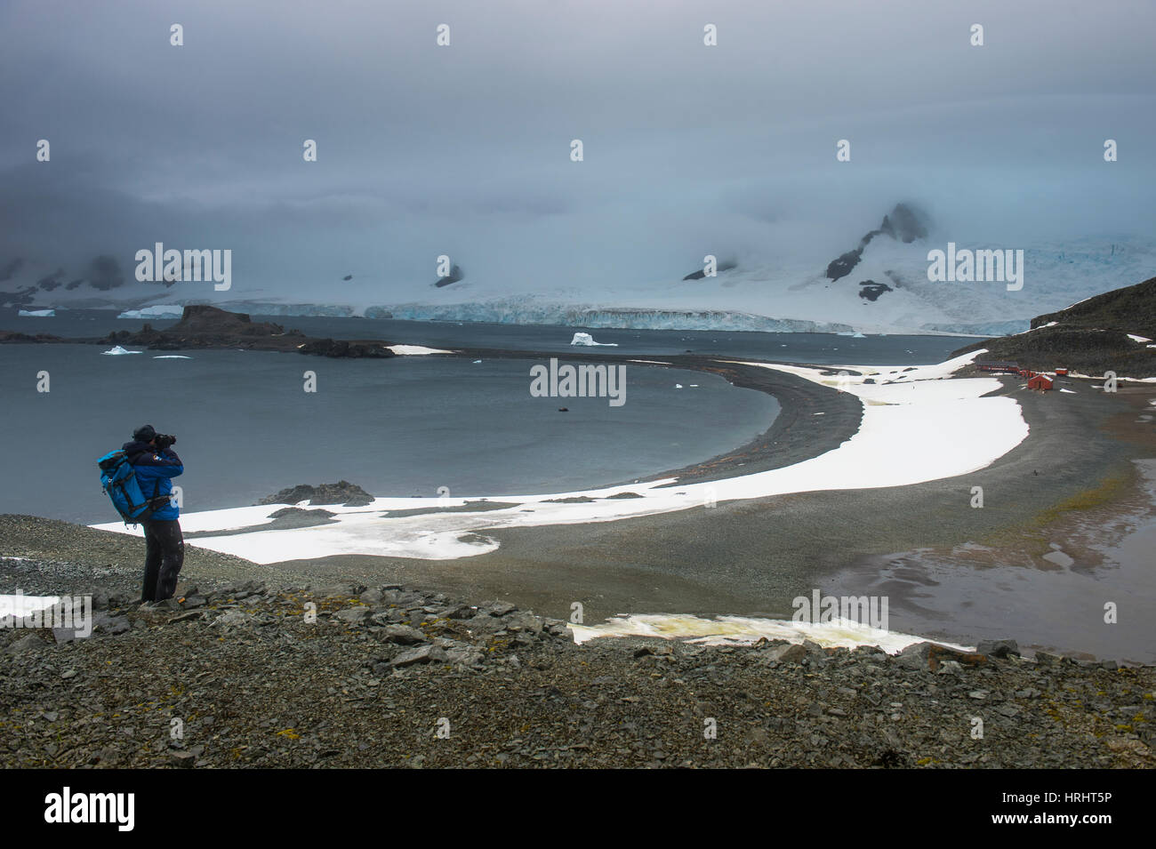 Tourist photographing from an overlook over Half Moon Island, South Shetland Islands, Antarctica, Polar Regions Stock Photo