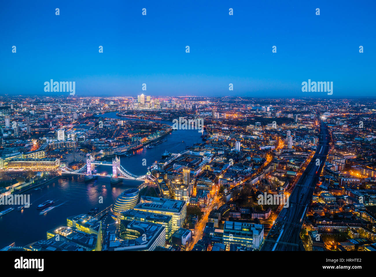 High view of London skyline at dusk along the River Thames from Tower Bridge to Canary Wharf, London, England, United Kingdom Stock Photo