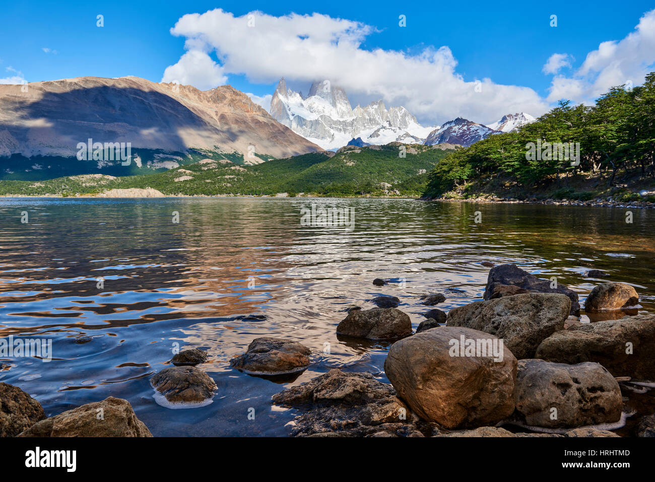 Wide angle shot of Capri Lagoon featuring Monte Fitz Roy in the background and rocks in the foreground, Patagonia, Argentina Stock Photo