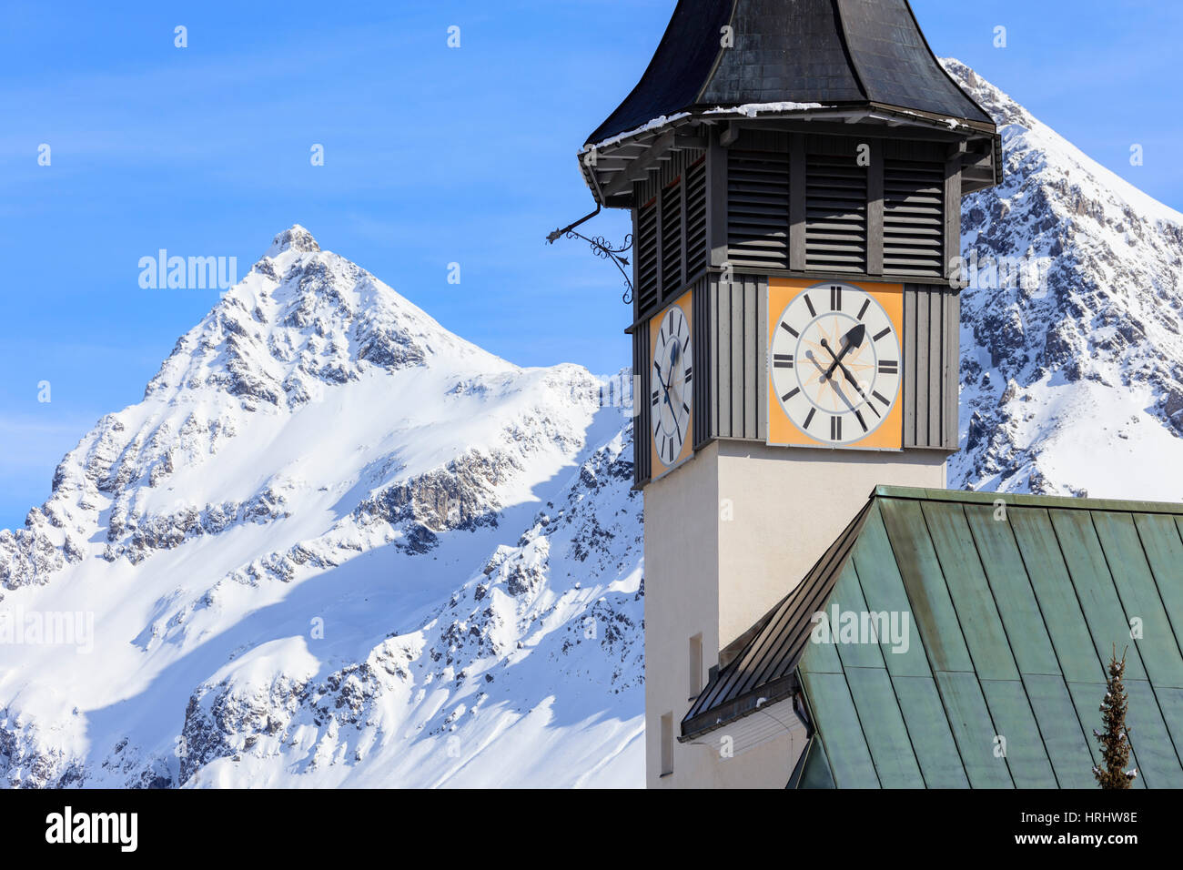 The typical alpine bell tower frames the snowy peaks, Langwies, district of Plessur, Canton of Graubunden, Switzerland Stock Photo
