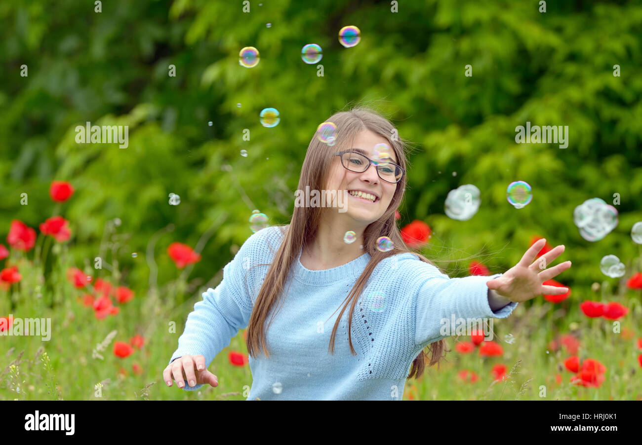 Girl Catching Soap Bubbles on spring field Stock Photo - Alamy