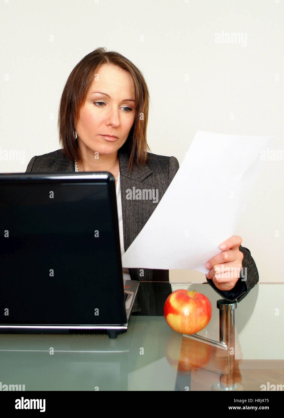 Gesch?ftsfrau arbeitet am Notebook, daneben liegt ein Apfel - business woman using laptop, aside an apple Stock Photo