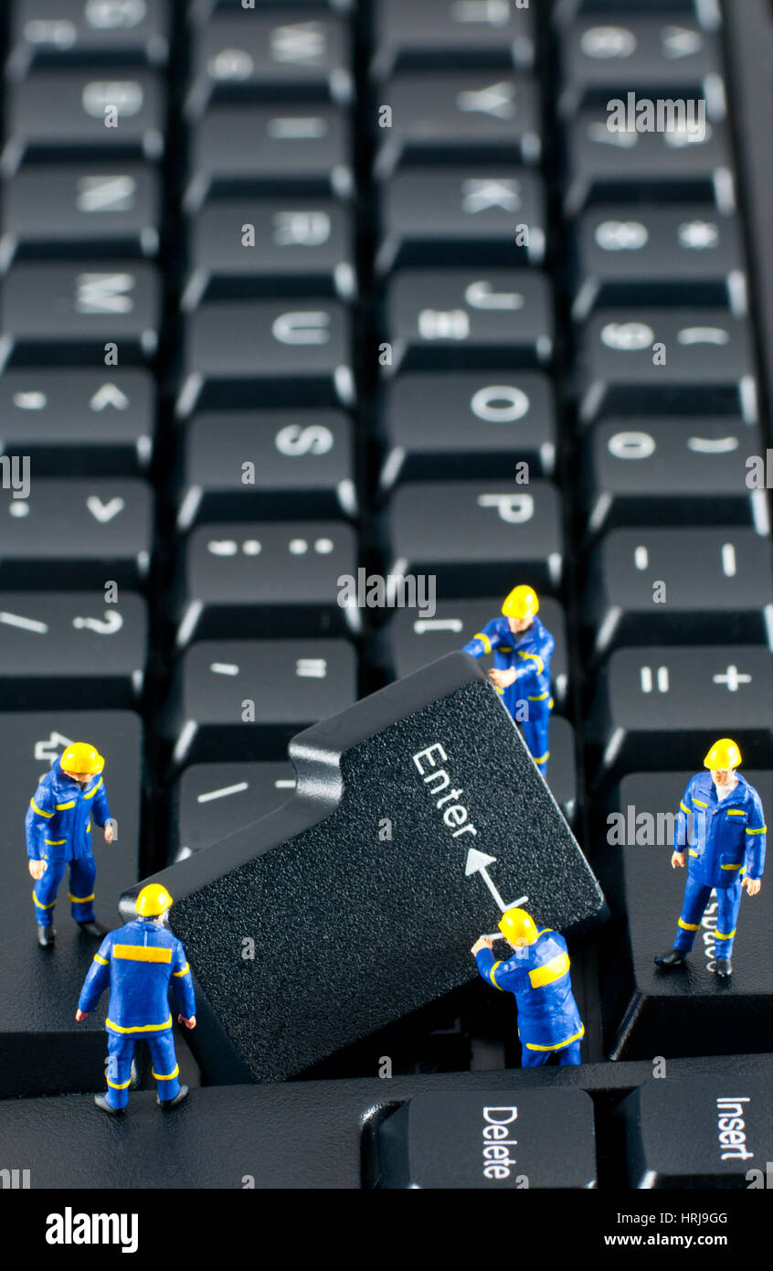 Team of construction workers working with ENTER button on a computer keyboard Stock Photo