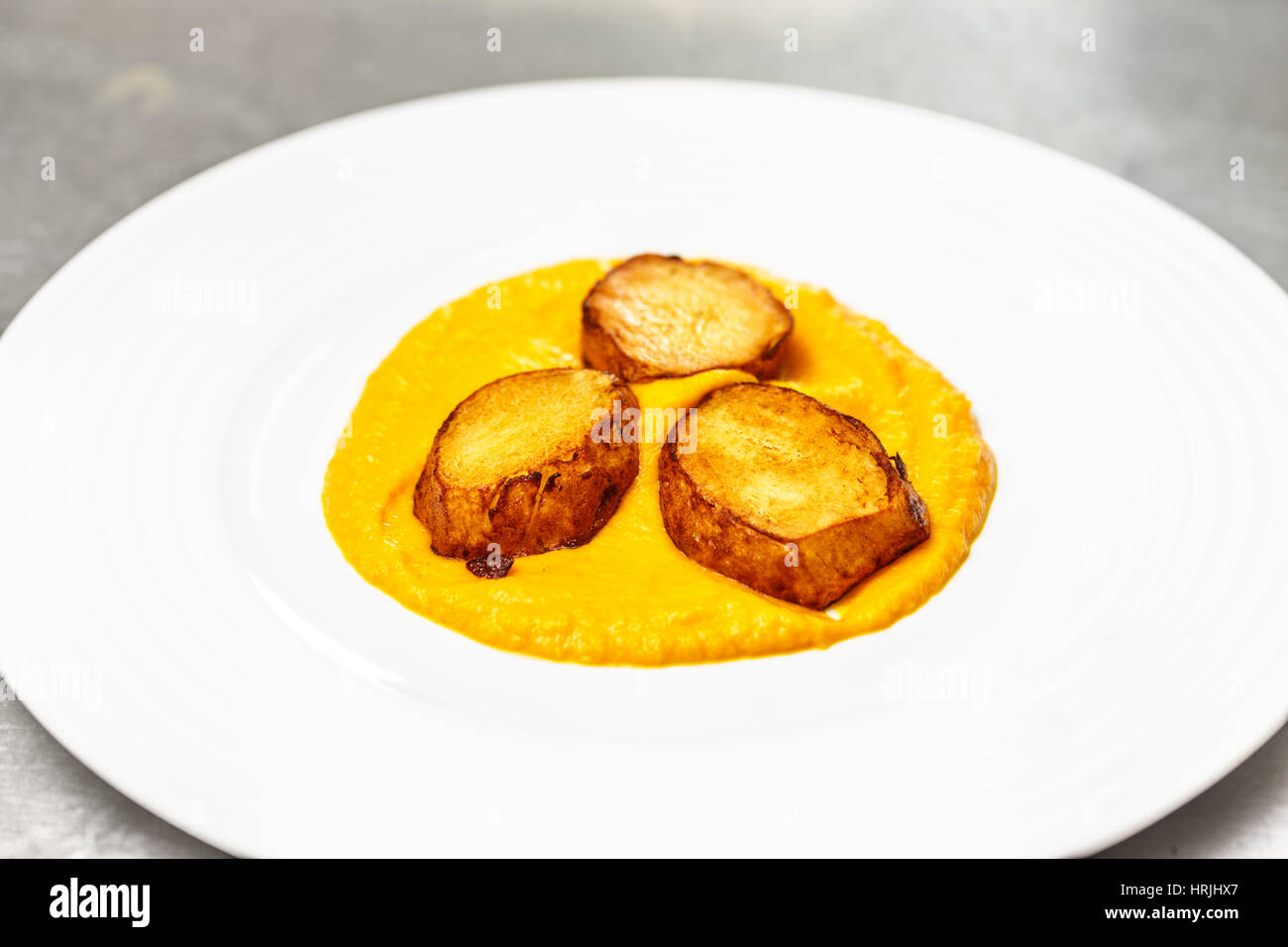 Carrot puree with grilled potato, vegetarian food concept Stock Photo