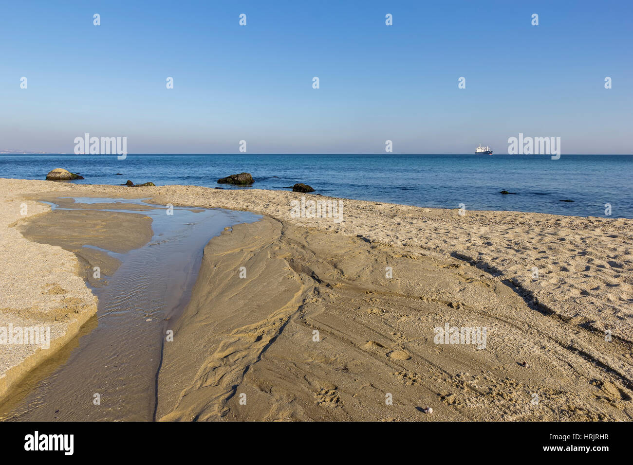 Day view of a small river flowing into the sea Stock Photo