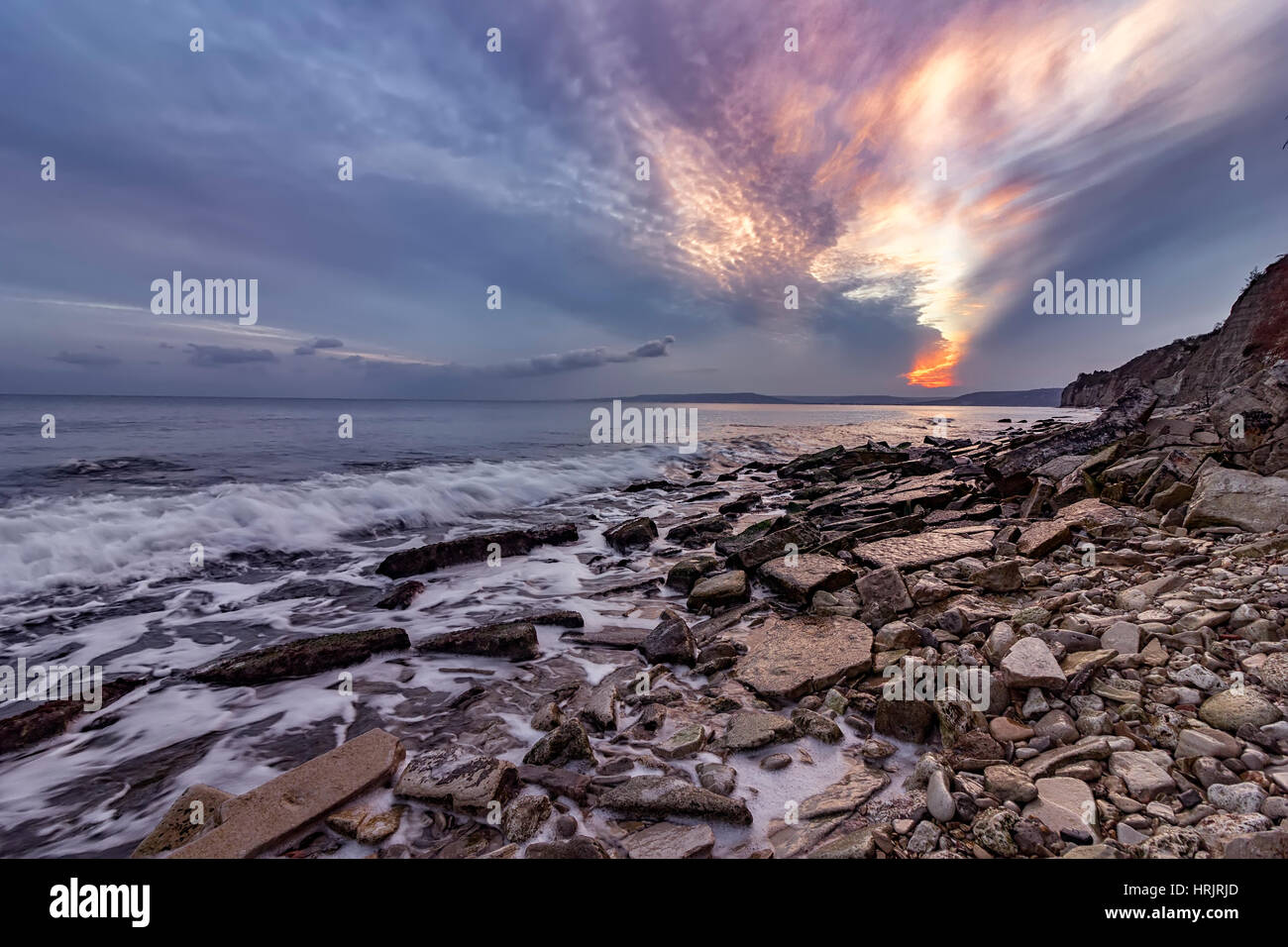 Exciting autumn sunset.Beauty sea rocky coast and cleavage sky Stock Photo