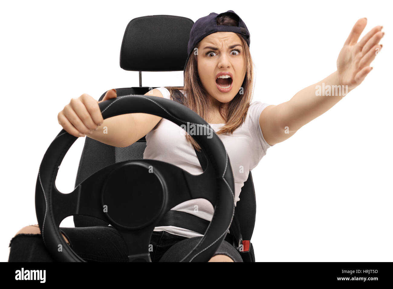 Angry teenage driver holding a steering wheel and gesturing with her ...