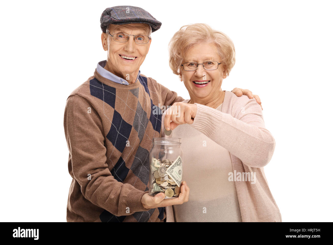 Elderly man holding a money jar with an elderly woman putting a coin in it isolated on white background Stock Photo