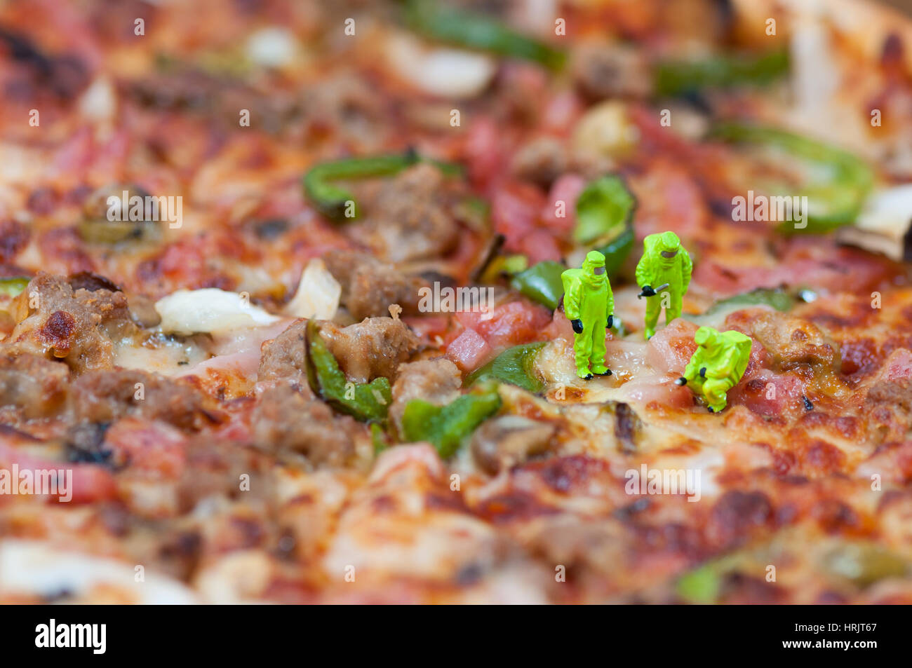 Scientists inspecting giant pizza. Unhealthy food concept. Macro photography Stock Photo