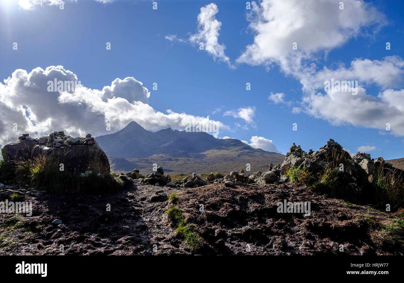 Group of stone cairns with background of mirroring the shapes of the dramatic peaks of the Cuillin mountain range in Isle of Skye Scotland Stock Photo