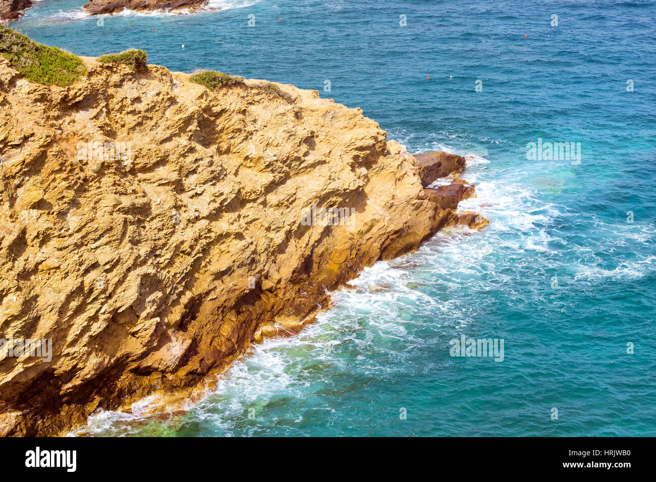 Waves break on rocky shore. Coast and beach resort village. Clear day at sea. Tourist beach resort in village of Bali, Crete island, Greece, Beach Cav Stock Photo