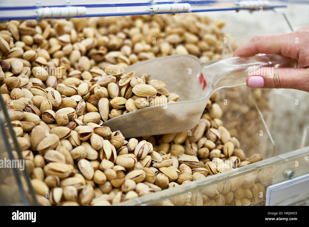 Buyer takes the pistachio nuts in the store Stock Photo