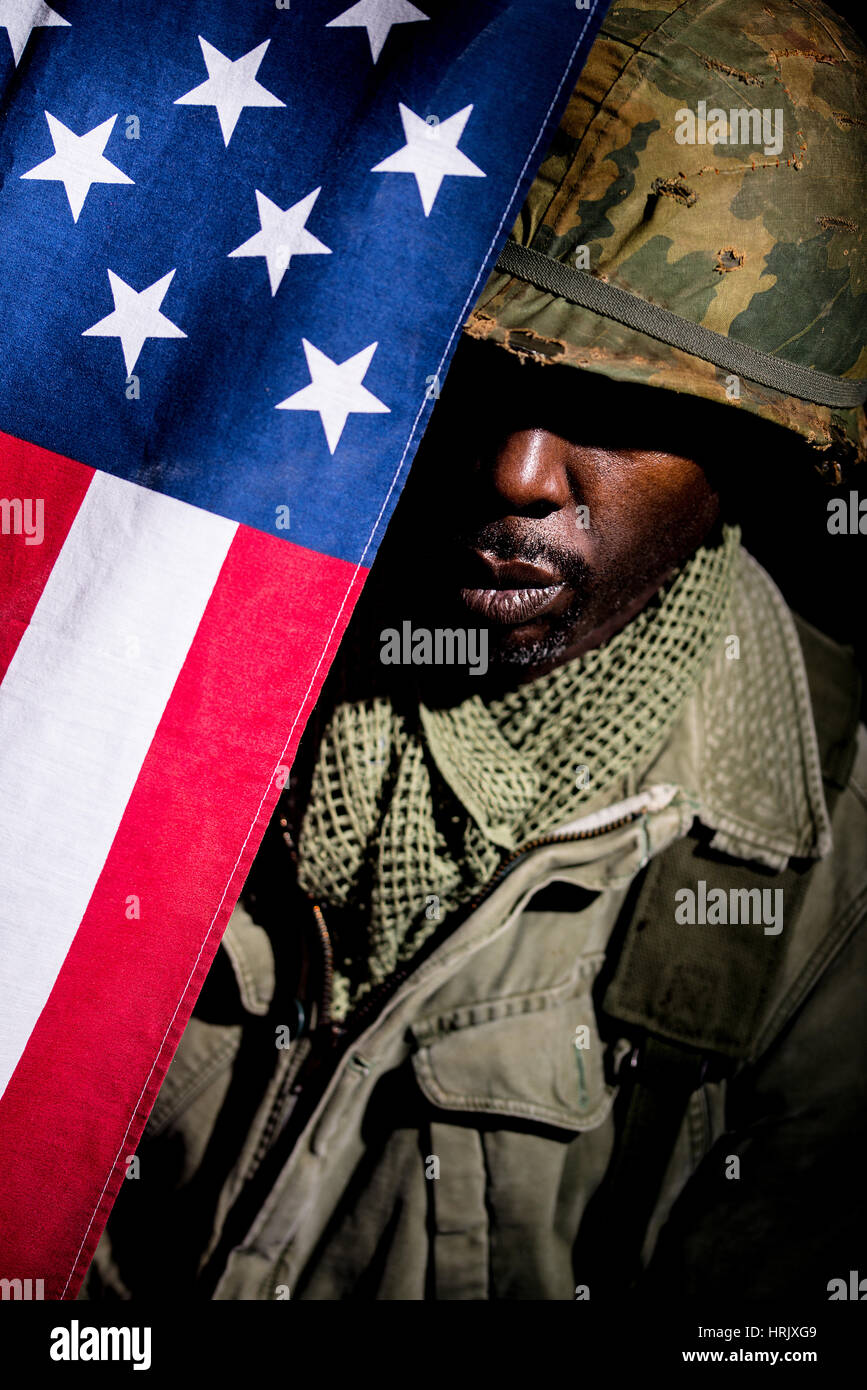 Portrait of African-American soldier from the Vietnam War period against a black background. Dark shadows used for a more dramatic image. Stock Photo