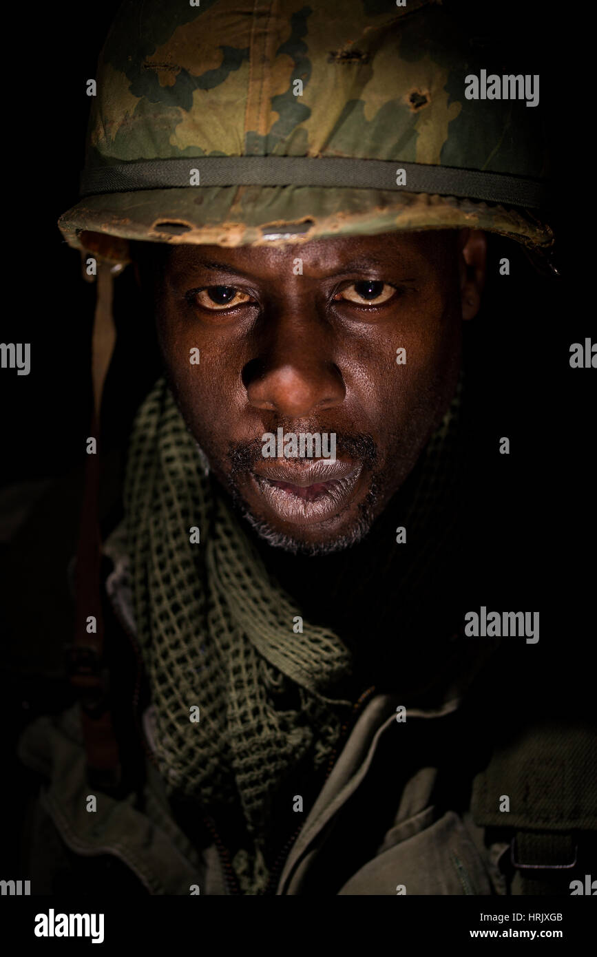 Portrait of African-American soldier from the Vietnam War period against a black background. Dark shadows used for a more dramatic image. Stock Photo