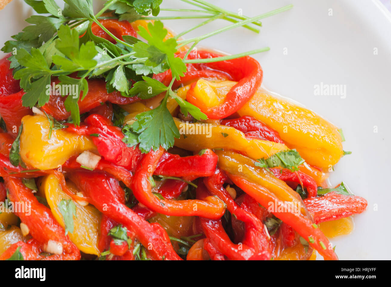 Dish of red and yellow peppers with garlic and parsley Stock Photo - Alamy