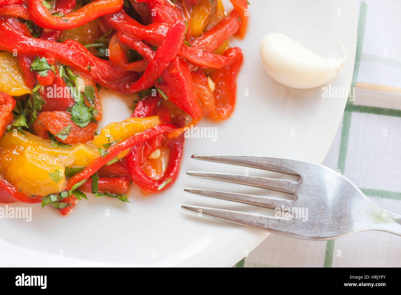 Dish of red and yellow peppers with garlic and parsley Stock Photo - Alamy