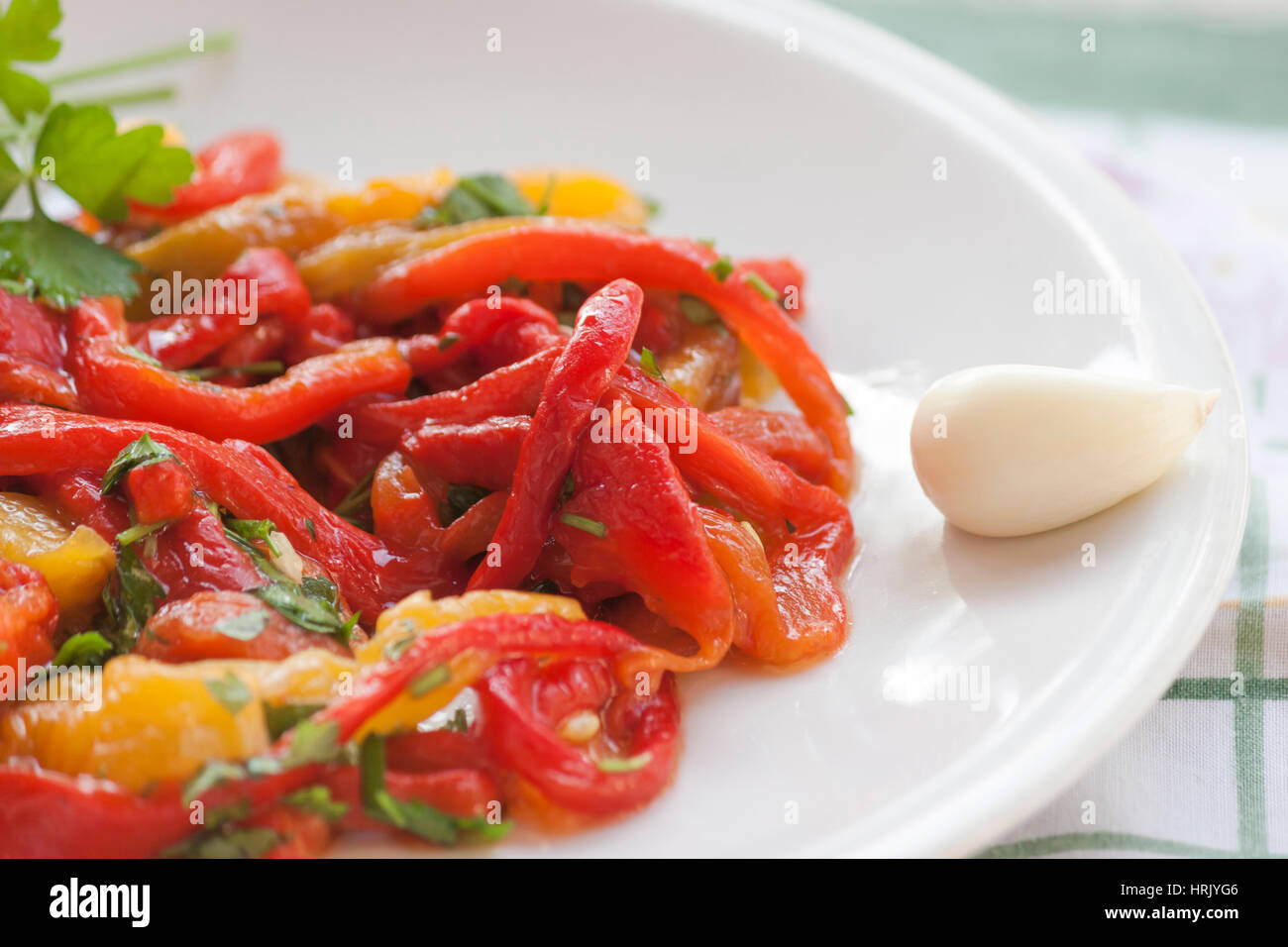 Dish of red and yellow peppers with garlic and parsley Stock Photo - Alamy