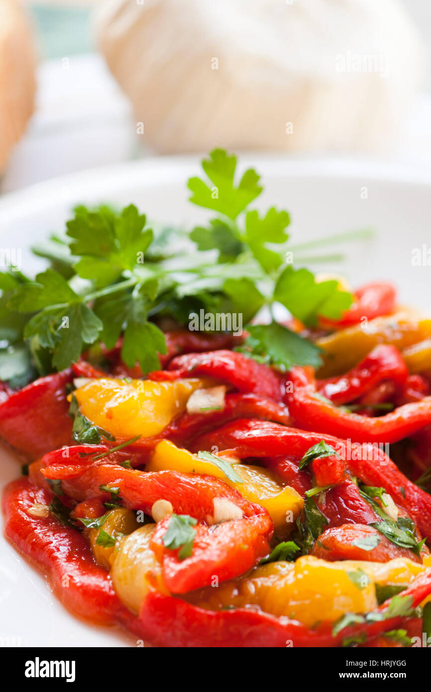 Dish of red and yellow peppers with garlic and parsley Stock Photo - Alamy