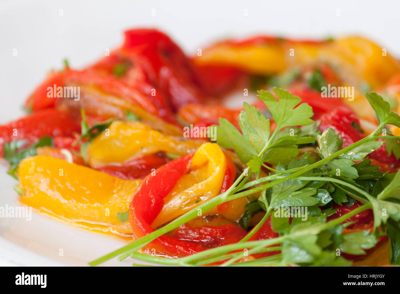 Dish of red and yellow peppers with parsley Stock Photo - Alamy