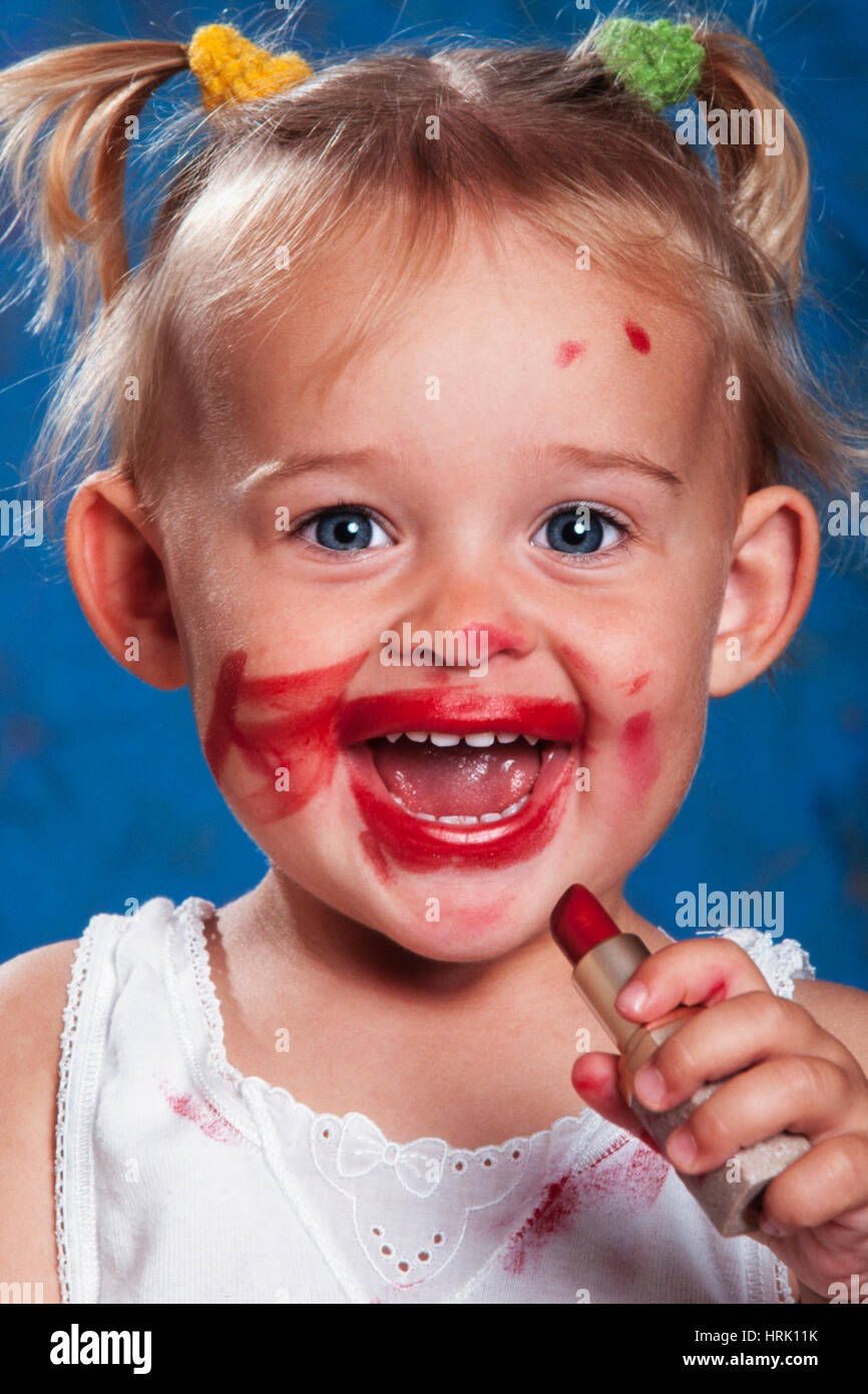 Four year old girl putting on lipstick, portrait, Tyrol, Austria Stock