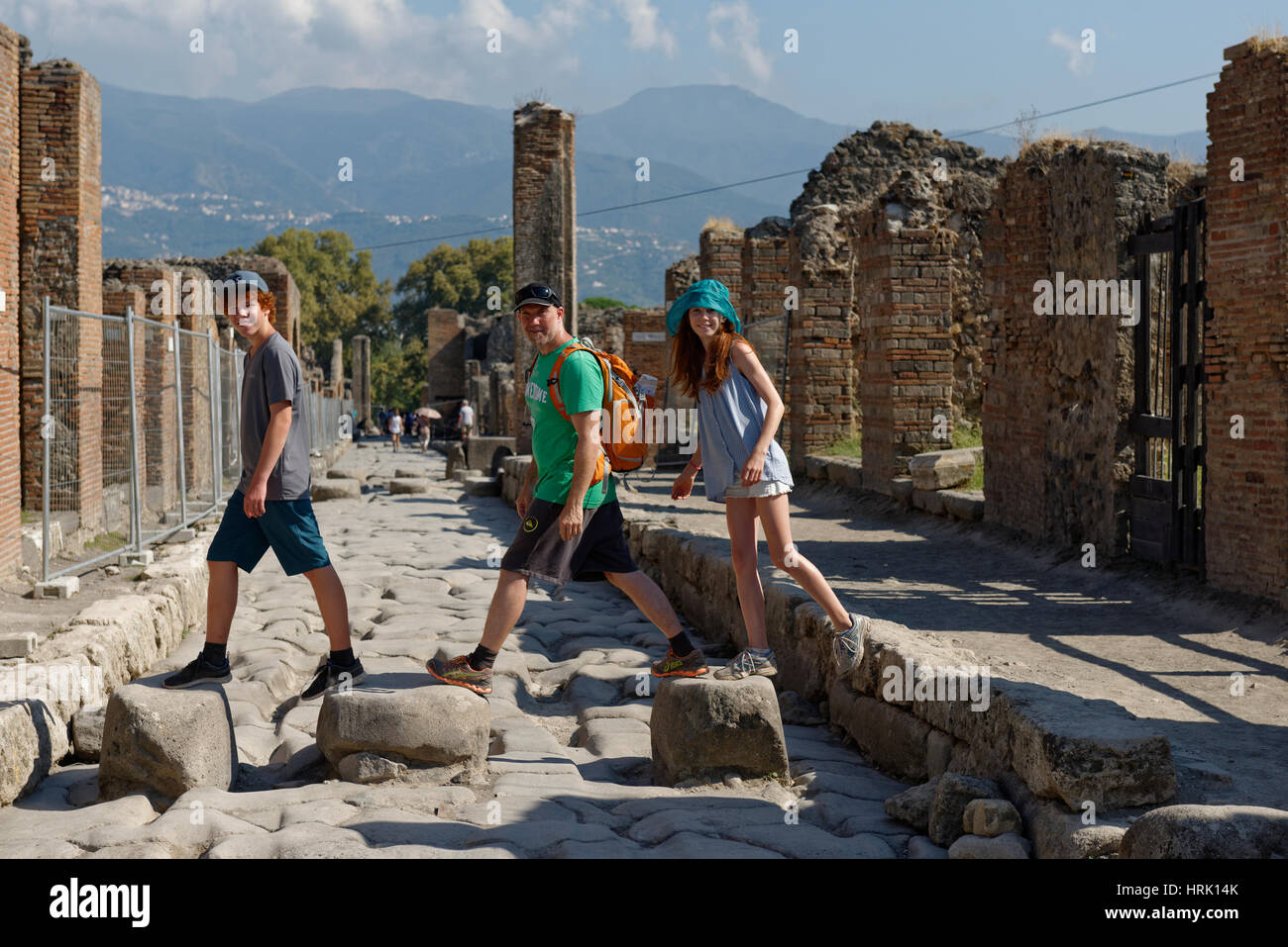 Father and children walking on historical stones, Via Stabiana, ancient city, Pompeii, Campania, Italy Stock Photo
