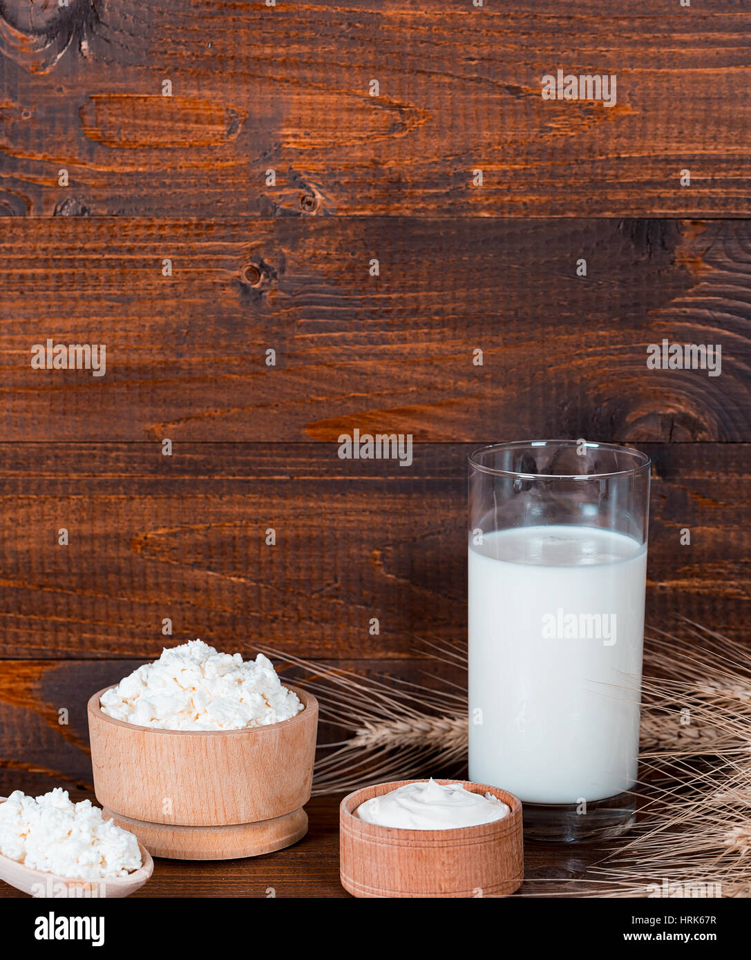 Natural homemade products: milk, cheese, sour cream and eggs on old wooden background with ears of wheat. With space for your text Stock Photo